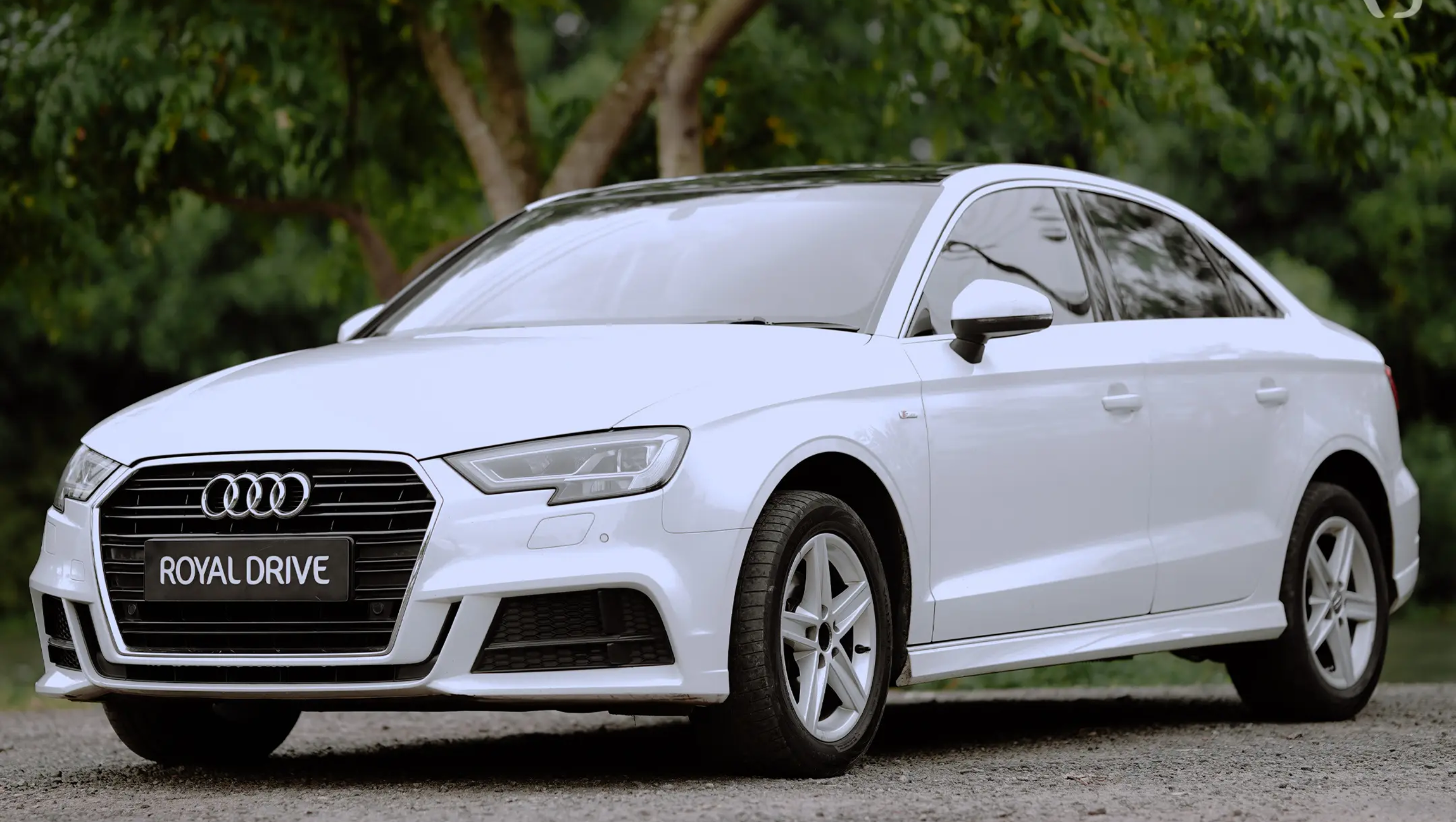 Sleek white vehicle on gravel road