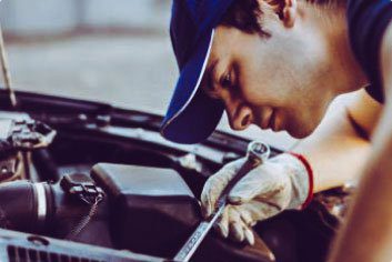 Man using wrench on car engine