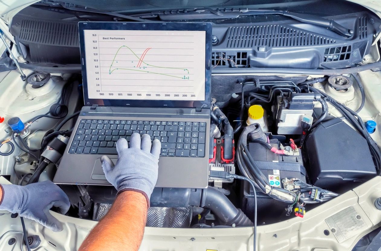 Mechanic using laptop for engine diagnostics